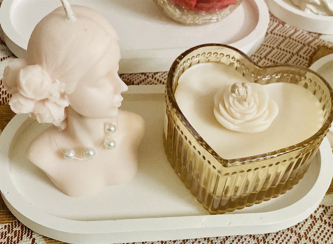 Beauty Lady sculpted candle beside a heart glass jar