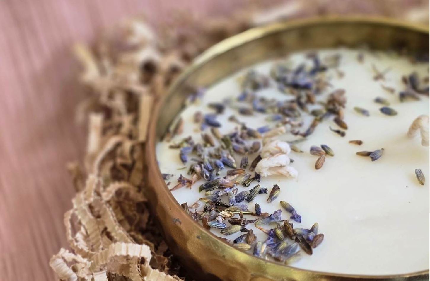 Soy wax candle in a hammered brass urli, scattered with dried lavender