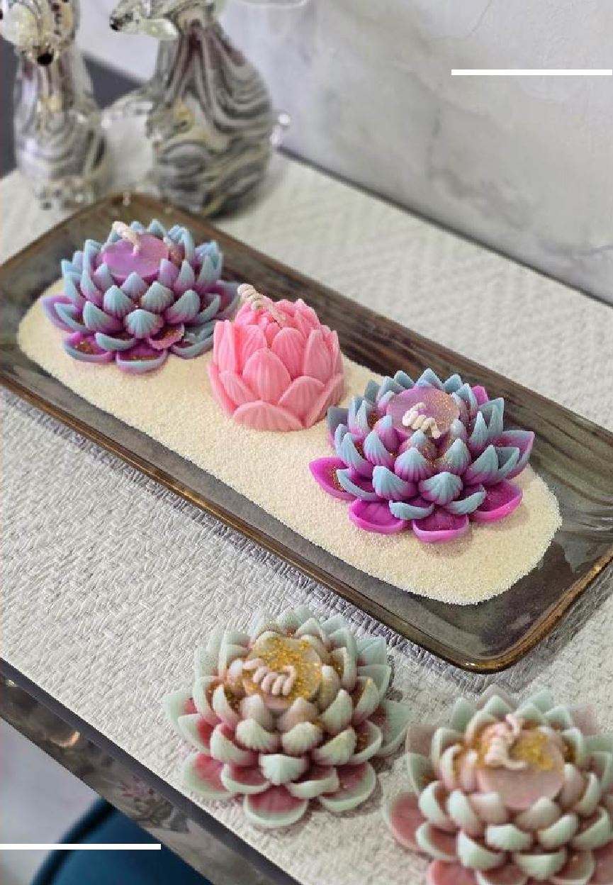 Lotus candles arranged on a sand-filled tray